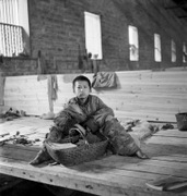 China 1944: A destitute boy with a wicker basket in the Poor People's Refuge in Changsa. Beaton, Cecil, 1904-1980